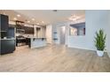Open floor plan with wood tile flooring connecting the kitchen and living areas at 320 San Antonio River St, North Las Vegas, NV 89084