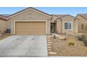 Inviting single-story home featuring desert landscaping, a two-car garage, and stone pathway at 3220 Flinthead Dr, North Las Vegas, NV 89084