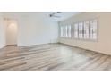 Bright, spacious living room featuring wood-look floors and plantation shutters on the windows at 3220 Flinthead Dr, North Las Vegas, NV 89084