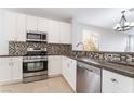 Modern kitchen featuring stainless steel appliances, granite countertops, and tiled flooring at 4546 Regalo Bello St, Las Vegas, NV 89135