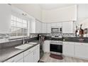 Well-lit kitchen featuring white cabinets, stainless steel appliances, and backsplash at 5448 Cove Point Dr, Las Vegas, NV 89130