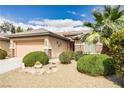 Charming single-story home featuring a well-maintained front yard with desert landscaping, front shrubs, and a palm tree at 5944 Saddle Horse Ave, Las Vegas, NV 89122