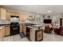 Open-concept kitchen with breakfast bar, black appliances, and tiled flooring at 682 Baffin Island Rd, Henderson, NV 89011