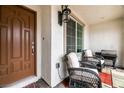 Cozy covered front porch with comfortable seating and dark wicker furniture at 795 Pickled Pepper Pl, Henderson, NV 89011