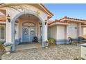 Charming entryway with double doors, a tiled porch, and decorative potted plants enhancing curb appeal at 905 White Thunder St, Henderson, NV 89002