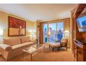 Cozy living room featuring a comfortable sofa, armchair, and city views from the balcony at 125 E Harmon Ave # 2801&2803, Las Vegas, NV 89109