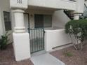 Close-up of a stucco condominium building's gated front patio featuring a secure wrought iron gate at 1341 Cinder Rock Dr # 101, Las Vegas, NV 89128