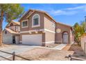 Inviting front exterior showcases a two-story design with a two-car garage and a charming, landscaped yard at 1892 Falcon Ridge St, Las Vegas, NV 89142