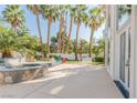Lush backyard featuring a pool, jacuzzi, and outdoor seating area surrounded by beautiful landscaping and palm trees at 2339 Prometheus Ct, Henderson, NV 89074
