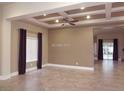 Open-concept living room with tiled flooring, stylish ceiling fan, and backyard access at 2744 Pala Dura Dr, Henderson, NV 89074