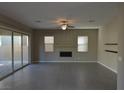 Spacious living room has tile flooring, fireplace, large windows, and sliding door to the backyard at 2822 Poseidon Shore Ave, Henderson, NV 89052