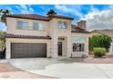 Inviting two-story home featuring a tile roof, arched entry, and a convenient attached two-car garage at 293 Winter Creek Ct, Henderson, NV 89074