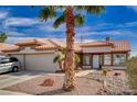 Front exterior view of a home with desert landscaping, palm tree, and a tile roof at 3509 Altar Rock Ln, North Las Vegas, NV 89032