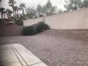A backyard with stone and block walls, gravel, and a concrete patio area at 405 Center Green Dr, Las Vegas, NV 89148