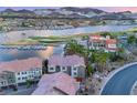 Scenic aerial view of a waterfront community with a golf course and clubhouse under a vibrant sky at 5 Via Vita Bella, Henderson, NV 89011