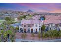 View of elegant townhomes featuring brick accents, balconies, and lush landscaping in a serene community at 5 Via Vita Bella, Henderson, NV 89011