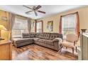 Inviting living room features hardwood floors, a ceiling fan, and large windows with decorative curtains at 8932 Jaquita Ave, Las Vegas, NV 89149
