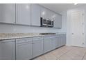 Charming kitchen with granite countertops, gray cabinets, and stainless steel microwave at 10373 Northern Hills Ave, Las Vegas, NV 89166