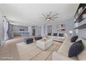 Spacious living room with modern ceiling fan and stylish furnishings adjacent to a kitchen with gray cabinetry at 10373 Northern Hills Ave, Las Vegas, NV 89166