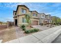 Two-story home with a two car garage and desert landscaping in the front yard at 1485 Sound Ln, North Las Vegas, NV 89031