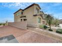 Side view of a two-story home showing its desert landscaping and brick walkway at 1485 Sound Ln, North Las Vegas, NV 89031