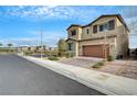 Street view of a two-story home with desert landscaping and a brick driveway at 1485 Sound Ln, North Las Vegas, NV 89031