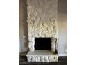 Close up of a fireplace with stone masonry around it, with hard wood floors at 1639 Justin Cir # 1639, Henderson, NV 89011