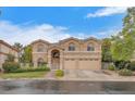 Two-story home with a symmetrical facade, arched windows, manicured landscaping and a three-car garage at 1923 Grey Eagle St, Henderson, NV 89074