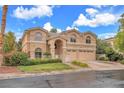 Two-story home with a symmetrical facade, arched windows, manicured landscaping and a three-car garage at 1923 Grey Eagle St, Henderson, NV 89074
