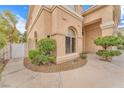 Close up of the home exterior, with arched windows, stucco finish, manicured shrubs, and a walkway at 1923 Grey Eagle St, Henderson, NV 89074