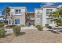Exterior of a well-maintained condo with stucco walls, desert landscaping and stairs leading to upper units at 2325 Windmill Pkwy # 1313, Henderson, NV 89074