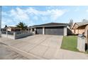 View of a two-car garage with an extended driveway and a well-kept lawn in a desirable neighborhood at 2549 Pine Creek Rd, Las Vegas, NV 89115