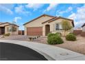 Single-story home with a brick driveway, desert landscaping, and a tan facade and a two car garage at 3018 Carothers Ct, North Las Vegas, NV 89032
