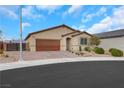 Single-story home with a brick driveway, desert landscaping, and a neutral colored facade and a two car garage at 3018 Carothers Ct, North Las Vegas, NV 89032