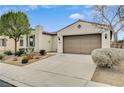 Home featuring desert landscaping, a two-car garage and beige stucco siding at 3717 Rocklin Peak Ave, North Las Vegas, NV 89081