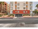 Building exterior with a gated parking area, landscaping, and brick accents on a cloudy day at 51 E Agate Ave # 506, Las Vegas, NV 89123
