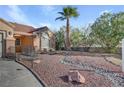 Single story home with terra cotta roof, desert landscaping with decorative rock and a two car garage at 540 Viva Serenade Way, Henderson, NV 89015