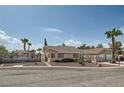 Street view of a single-story home with desert landscaping, featuring a decorative wagon wheel fence at 5775 W Desert Inn Rd, Las Vegas, NV 89146