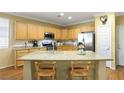 Well-lit kitchen with stainless steel appliances, granite countertops, and an island with seating at 7172 Painted Paradise St, Las Vegas, NV 89131