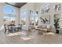 Open floor plan living room with dining area, large windows, and modern furnishings under a vaulted ceiling at 7904 Riviera Beach Dr, Las Vegas, NV 89128
