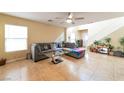 Bright living room features neutral tones, a ceiling fan, tiled floors, and abundant natural light at 8329 Brilliant Ruby Ct, Las Vegas, NV 89139