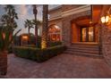 Close-up of the home's stone-accented front entrance with double doors and manicured landscaping at 9000 Thornbury Ln, Las Vegas, NV 89134