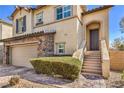 Beautiful two-story home featuring stone accents, a two-car garage, and a charming entryway at 10490 Palmadora St, Las Vegas, NV 89178