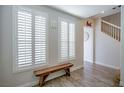 Inviting foyer with wood floors, a bench, plantation shutters, and staircase access at 1125 Via Canale Dr, Henderson, NV 89011