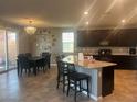 Spacious kitchen featuring granite countertops, dark cabinets, and a dining area with sliding doors at 2204 Valdina St, Henderson, NV 89044