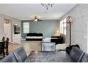 Open living room featuring brick accent wall and ceiling fan at 2204 Valdina St, Henderson, NV 89044