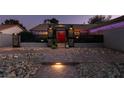 Inviting front yard with landscape lighting, brick walkway, decorative rock and wrought iron gated entry at 3083 Paintedhills Ave, Las Vegas, NV 89120