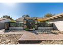 Charming home with xeriscape landscaping, decorative rock, brick walkway, and wrought iron gated entry at 3083 Paintedhills Ave, Las Vegas, NV 89120