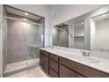 Contemporary bathroom with a glass-enclosed shower, double vanity, and a large mirror at 3346 Esker Ridge Ave, Henderson, NV 89044