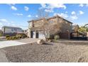Spacious two-story home with a three-car garage, rock landscaping and a desert-style yard at 3386 W Haleh Ave, Las Vegas, NV 89141